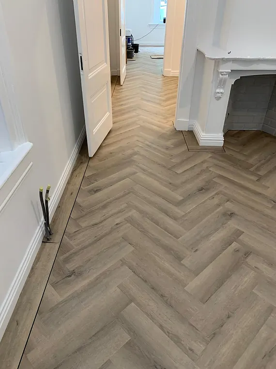 Grijs-eiken visgraatvloer in een kamer met paneeldeuren en sierschouw